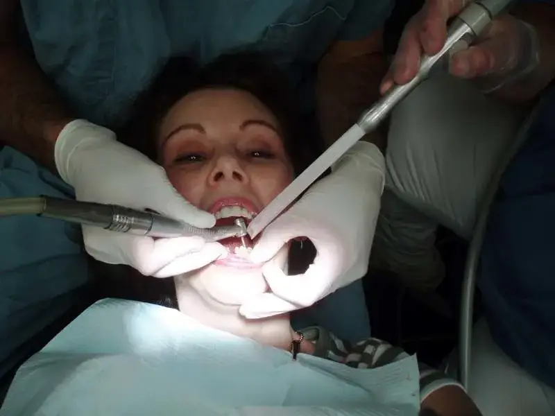 dentysta bada pacjenta z b&oacute;lem zęba