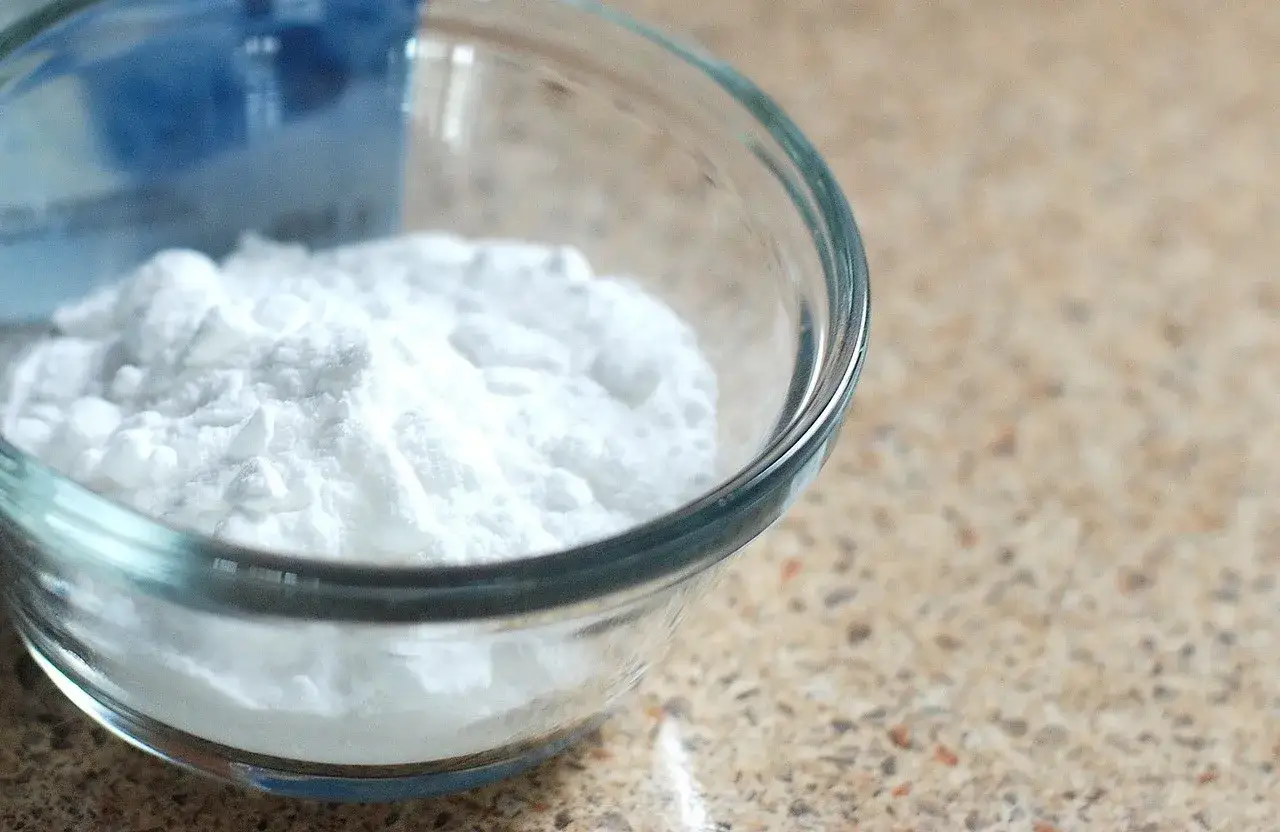 Biały proszek w szklanej miseczce, kt&oacute;ry może być odpowiedzią na pytanie, czy soda oczyszczona jest zdrowa.