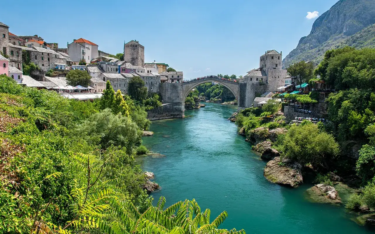 Mostar, Bośnia i Hercegowina. Malowniczy Stary Most nad turkusową rzeką Neretwą. Ceny w Bośni i Hercegowinie są przystępne, zwłaszcza w urokliwych restauracjach nad rzeką.