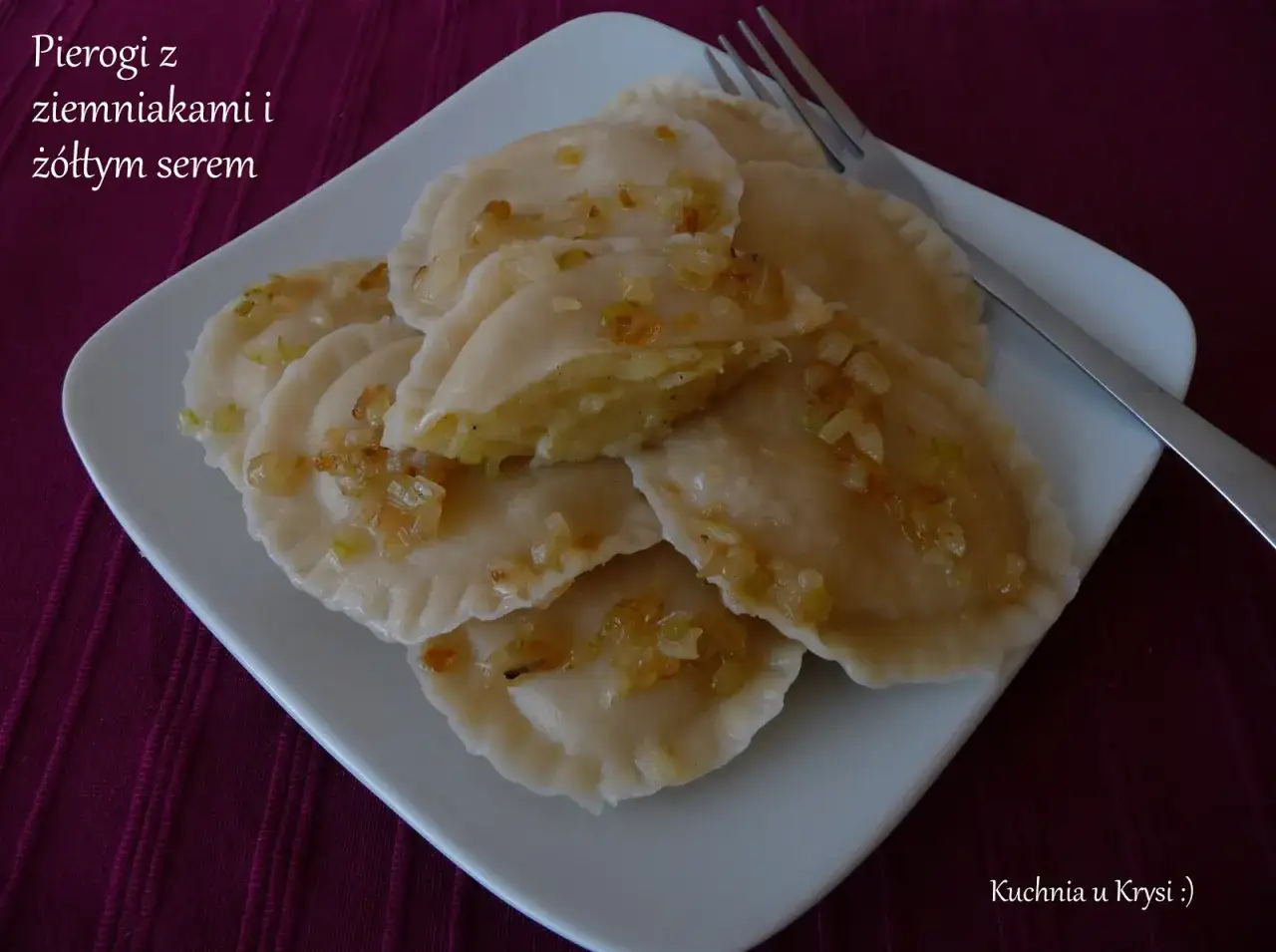 Pyszne pierogi z ziemniakami i ż&oacute;łtym serem, posypane podsmażoną cebulką, czekają na talerzu.