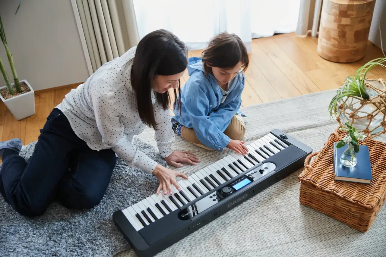 Kobieta i dziecko uczą się grać na keyboardzie Casio.
