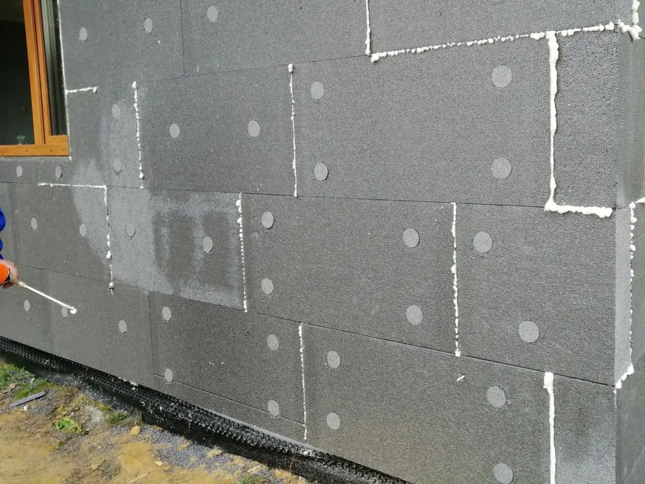 Piana montażowa aplikowana na płyty styropianowe, pokazująca jak przykleić styropian do ściany wewnętrznej.