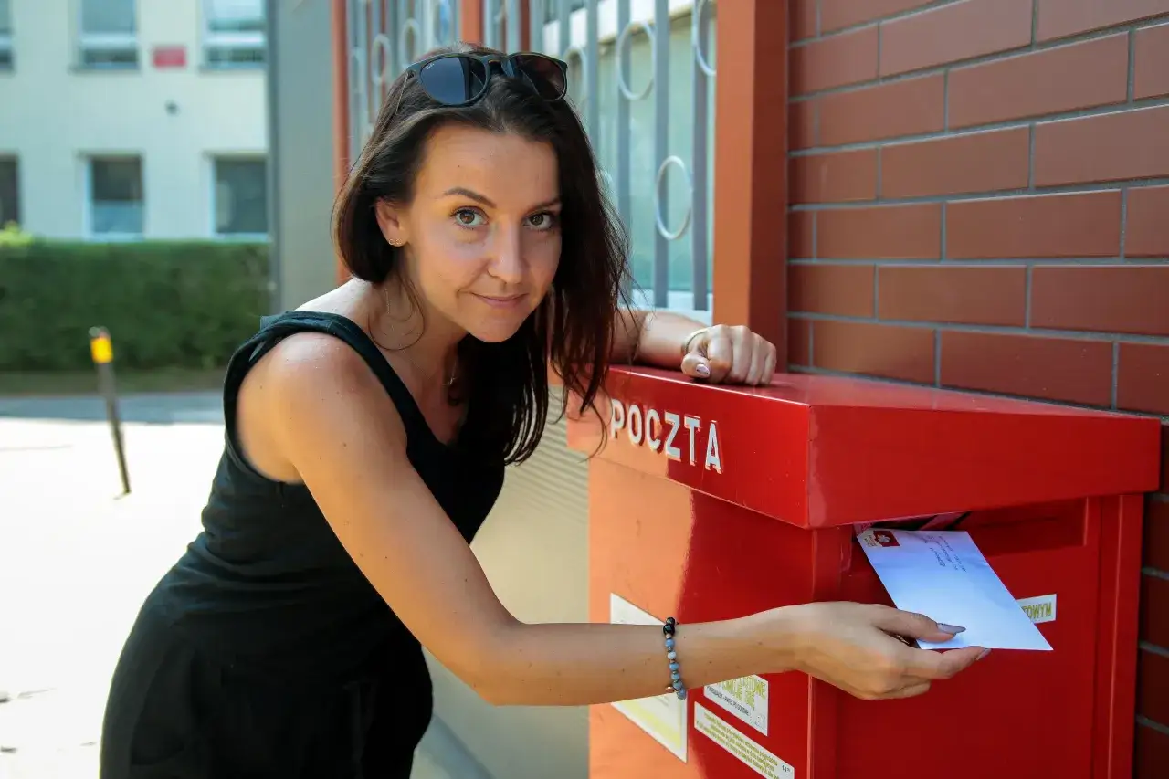 Osoba zastanawiająca się nad pisaniem kartki pocztowej