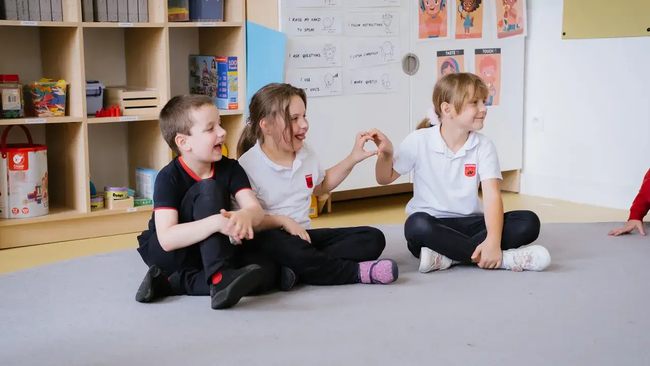 Dzieci uczące się w klasie nauczania zintegrowanego, nauczyciel wspiera aktywność