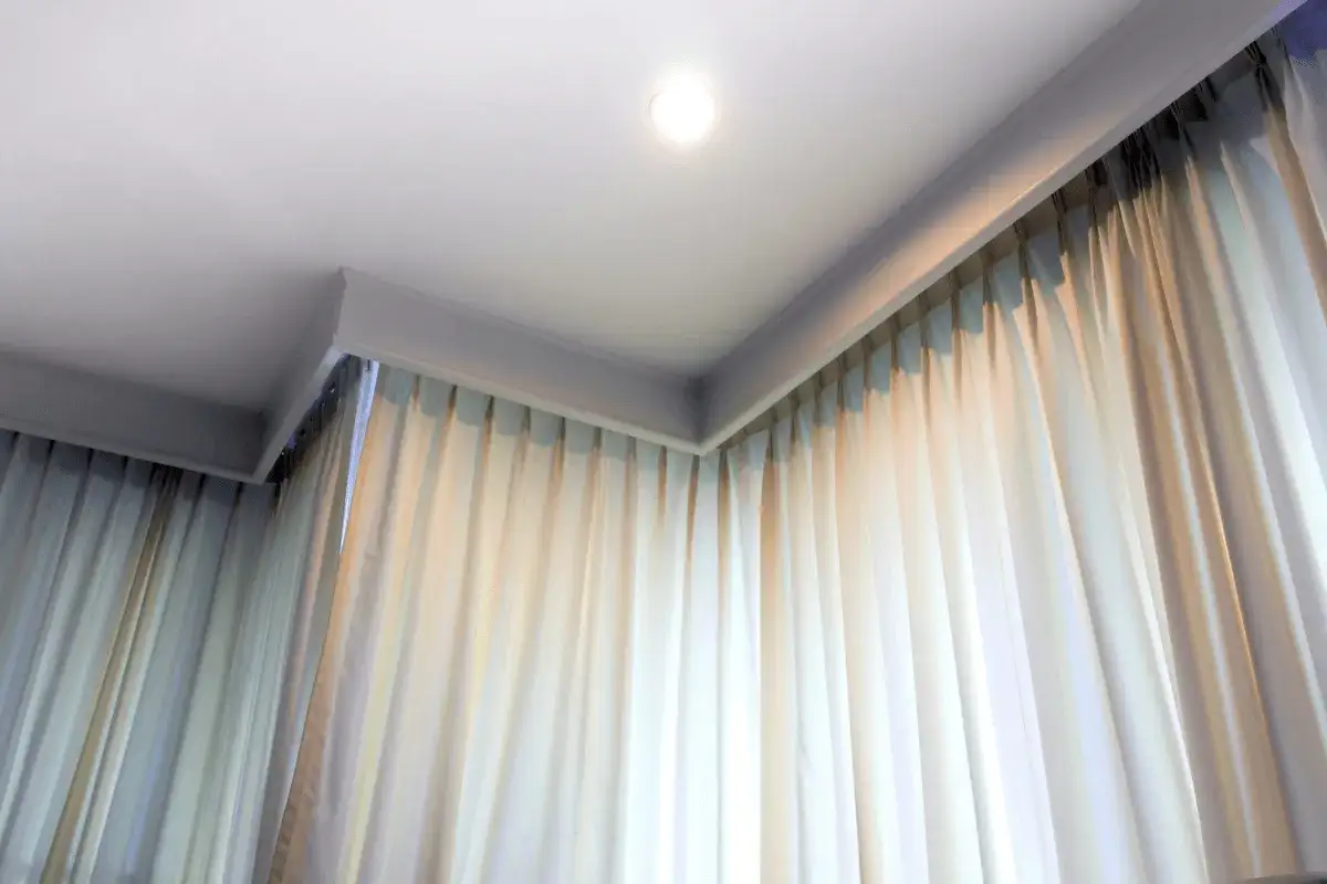 Elegancka zabudowa pod karnisz z zasłonami tworzy przytulną atmosferę.