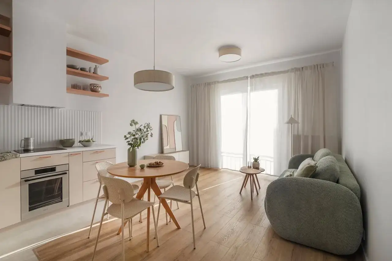 Nowoczesne oświetlenie salonu z jadalnią aranżacje: wisząca lampa nad stołem, plafon nad kanapą i subtelne światło z okna tworzą przytulną atmosferę.