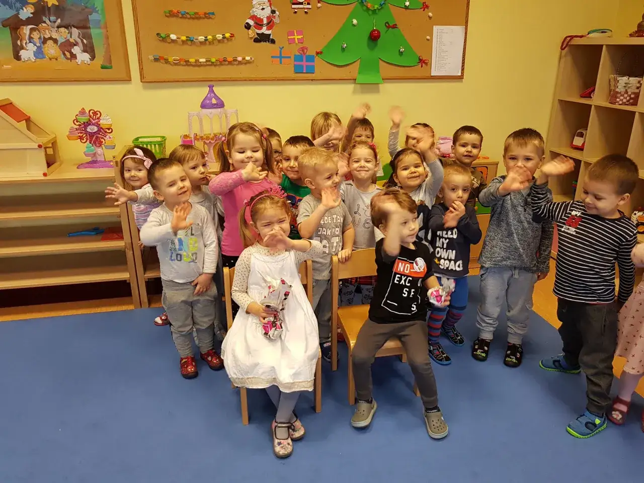 Dzieci machają radośnie, gotowe na wierszyki urodzinowe.