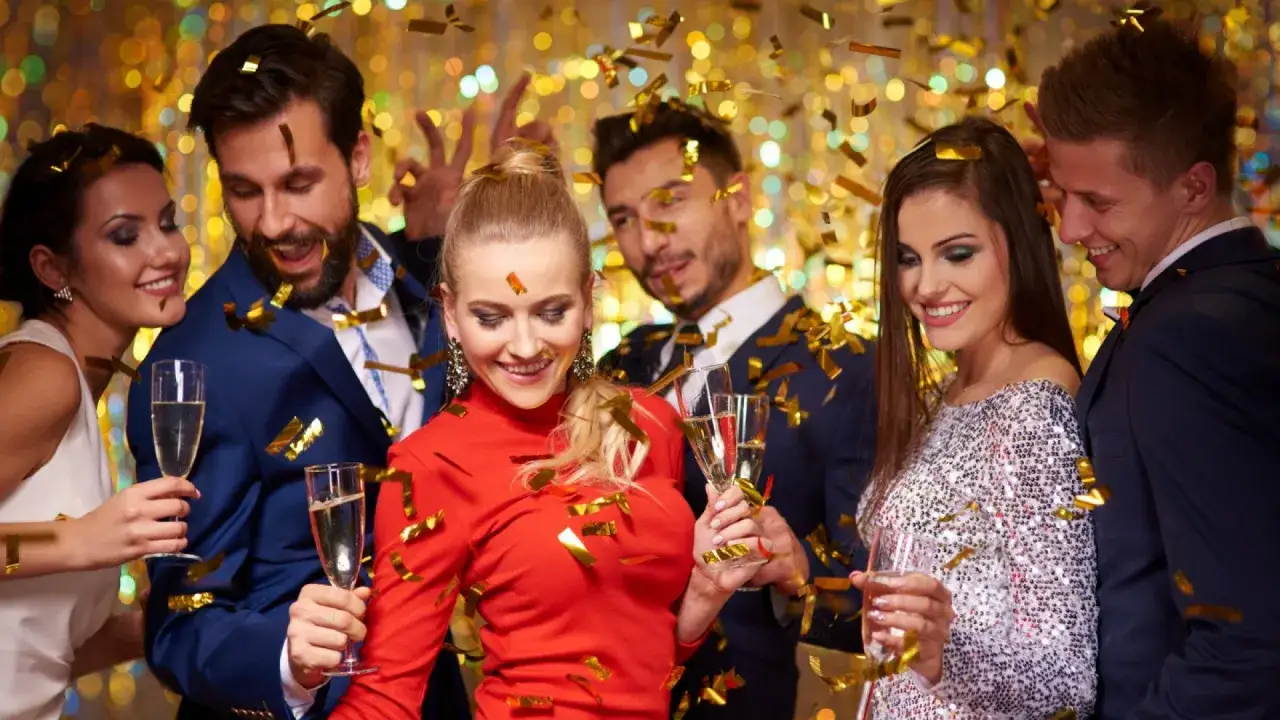 Szczęśliwi ludzie świętują sylwester w Wiśle, sypią się złote konfetti, wznoszą toasty szampanem.