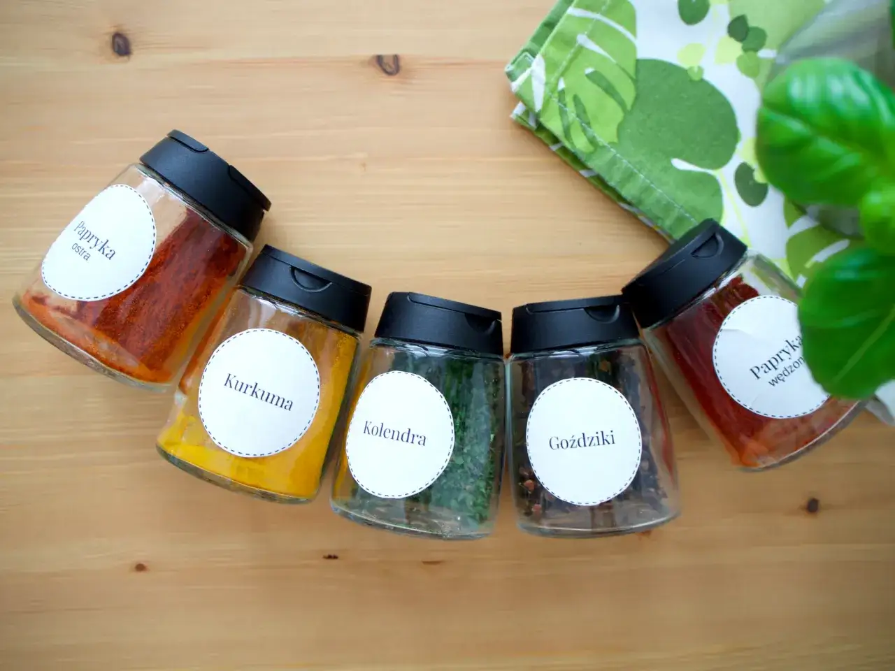 Sześć słoiczków z przyprawami: papryka, kurkuma, kolendra, goździki. Jak długo można przechowywać mielone przyprawy żeby nie straciły aromatu?