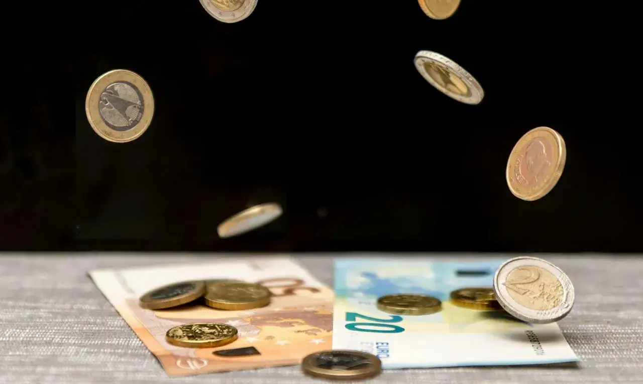 Monety euro spadają na banknoty. Czy w banku można wymienić walutę? Tak, to miejsce, gdzie można to zrobić.