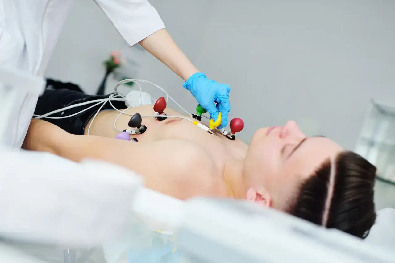 Lekarz zakłada elektrody do EKG młodemu mężczyźnie. Czy nerwica serca wyjdzie na EKG? Badanie serca.