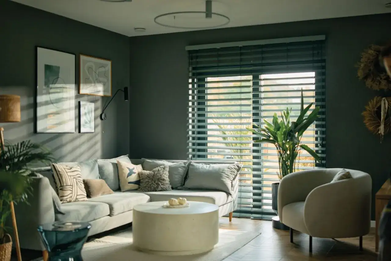 Nowoczesne żaluzje bambusowe idealnie komponują się z szarą sofą i minimalistycznymi dodatkami, tworząc przytulne aranżacje salonu.