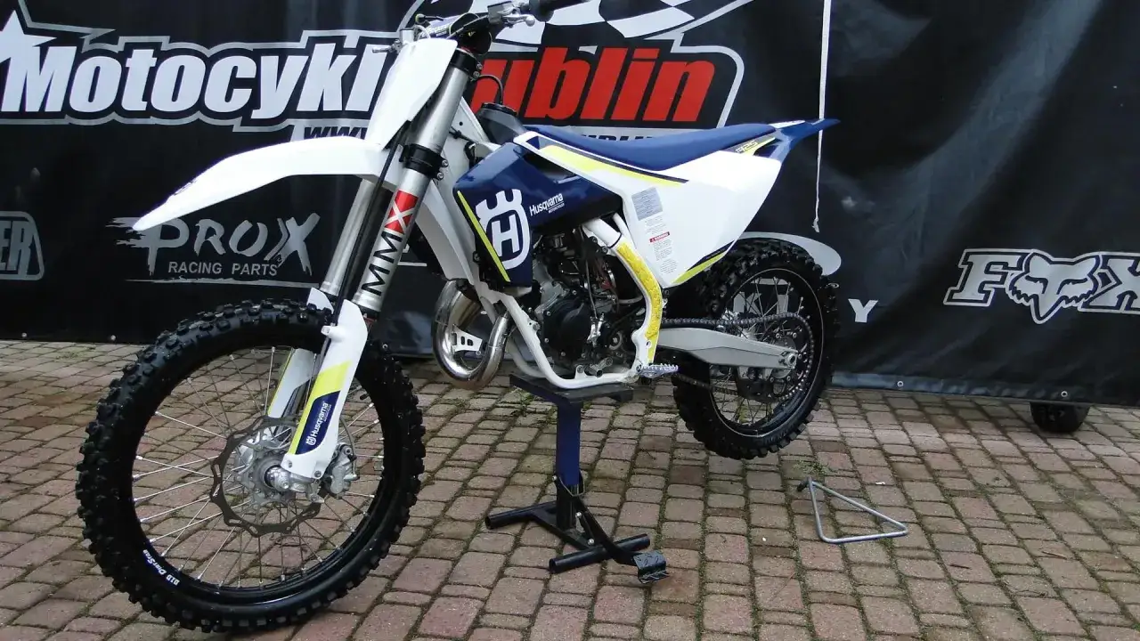 Husqvarna TC 125 gotowy do akcji. Biało-niebieski motocykl crossowy z ż&oacute;łtymi akcentami.