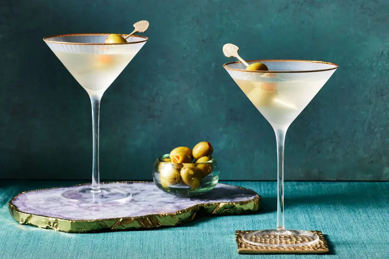 Dwa kieliszki martini extra dry z oliwkami, idealne do podania z czym pić.
