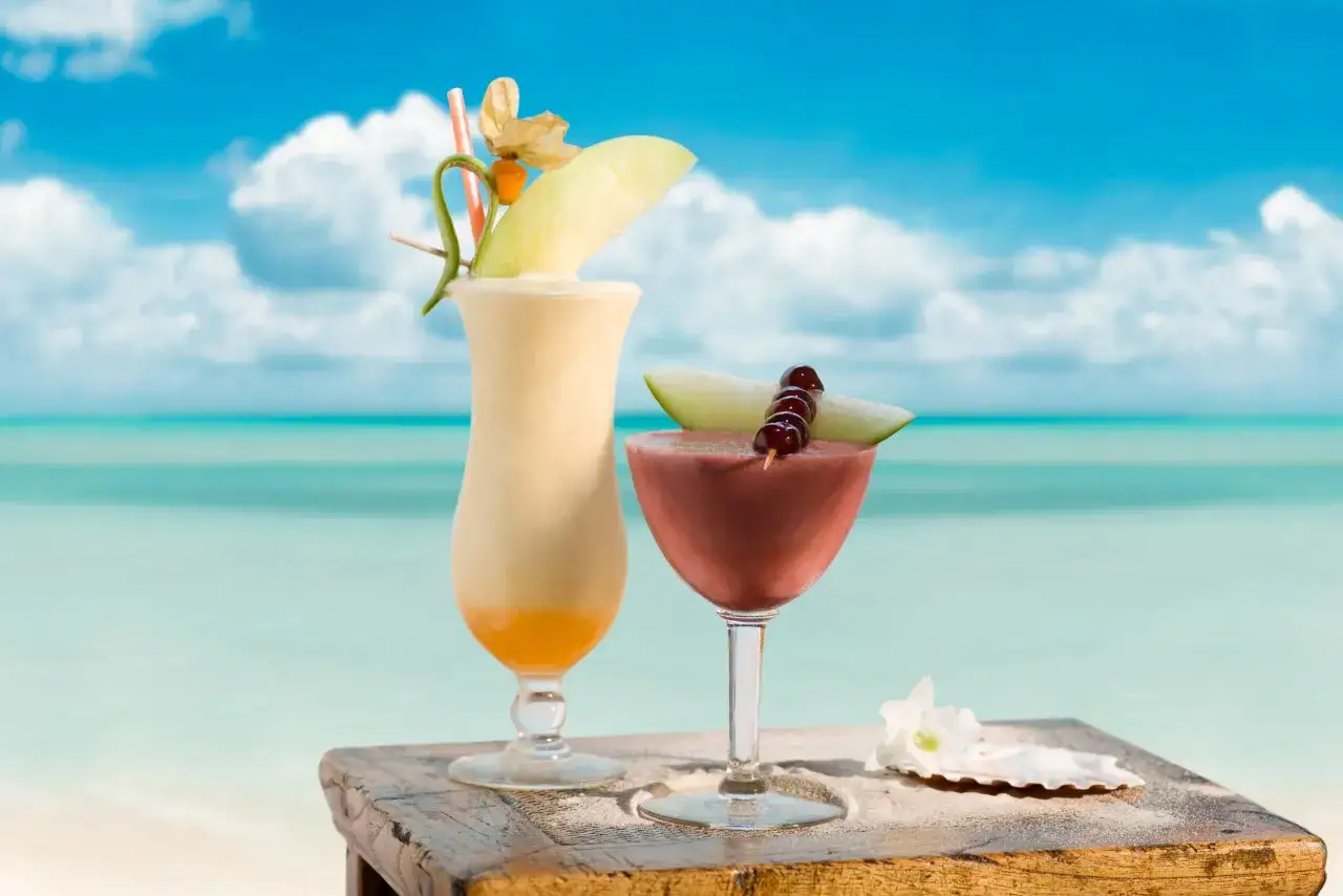 Dwa tropikalne drinki na plaży, idealne na lato. Poznaj przepis na Malibu drink!