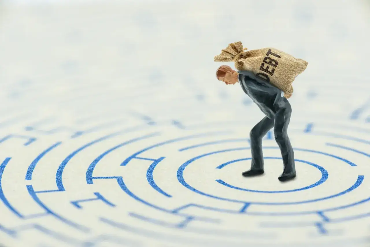 Osoba zmartwiona długami lub symbol spirali zadłużenia