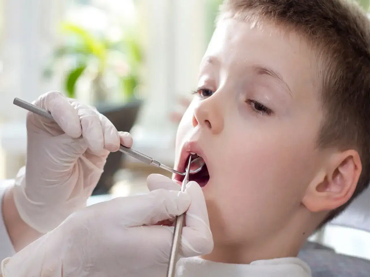 Chłopiec u dentysty, który sprawdza, kiedy wypadają jedynki górne.