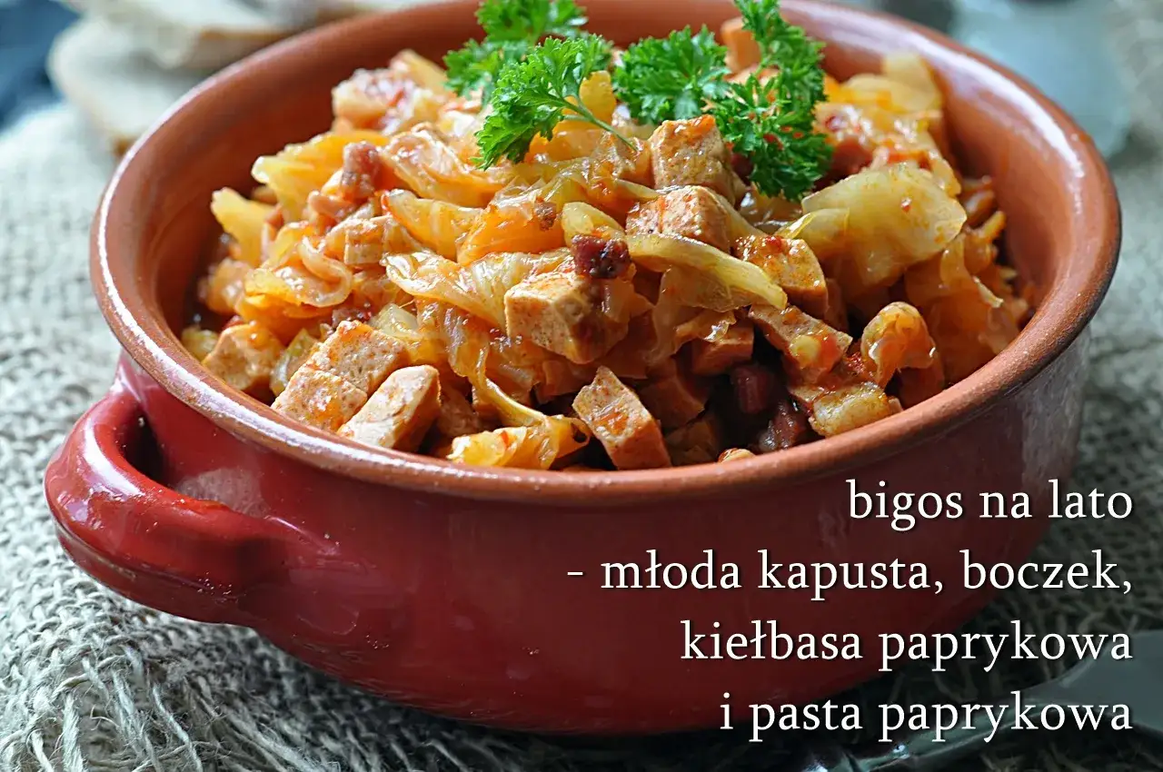 Młoda kapusta z koperkiem i kiełbasą w glinianej misie. Letni bigos na bazie młodej kapusty, boczku i paprykowej kiełbasy.