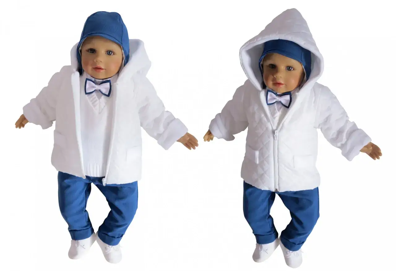 Elegancki zestaw na chrzest zimą: biała pikowana kurtka z kapturem, biały sweterek, niebieskie spodnie i czapka. Idealny pomysł, jak ubrać chłopca do chrztu zimą.