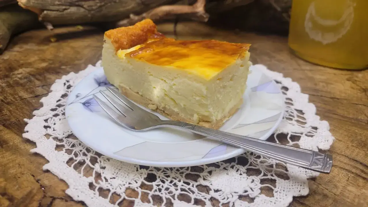 Kawałek tradycyjnego sernika na talerzyku z serwetką. Idealny przepis na sernik tradycyjny, kt&oacute;ry zachwyci każdego.