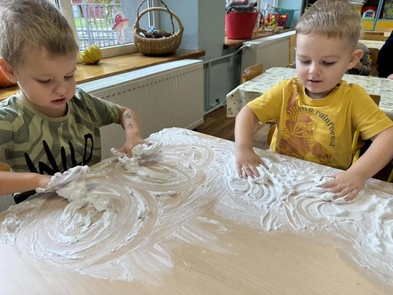 dziecko bawiące się pianką do golenia na stole