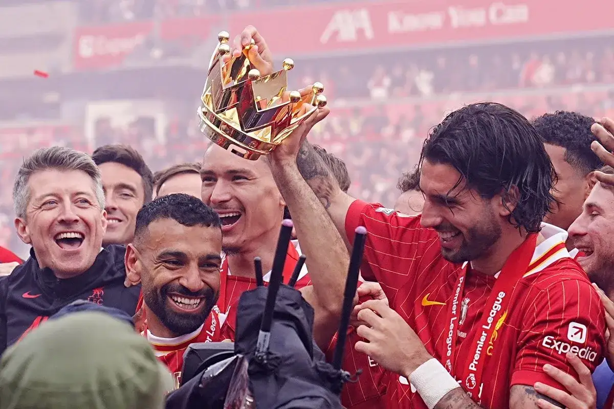 Piłkarze Liverpoolu świętują, jeden z nich trzyma koronę, symbolizującą tytuł króla strzelców Premier League.