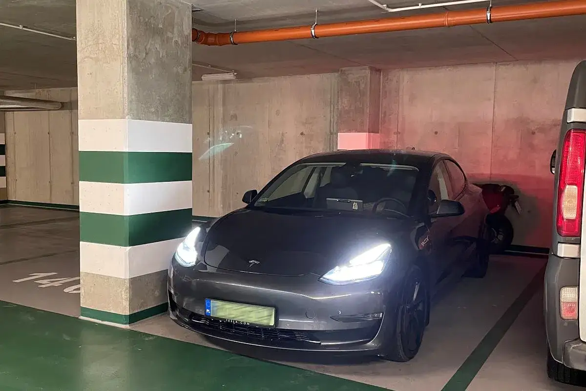 Szary Tesla w garażu podziemnym, gotowy do ładowania. Przepisy dotyczące ładowania samochodów elektrycznych w garażach podziemnych są ważne.