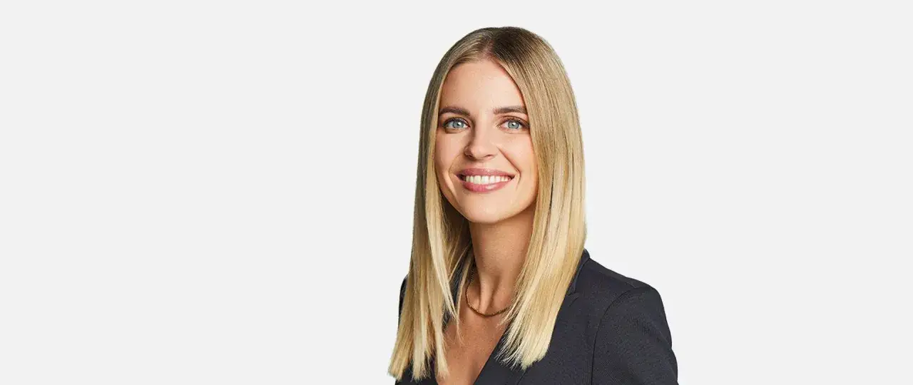 Uśmiechnięta Aleksandra Gajewska, której wykształcenie i profesjonalizm widać w jej spojrzeniu.