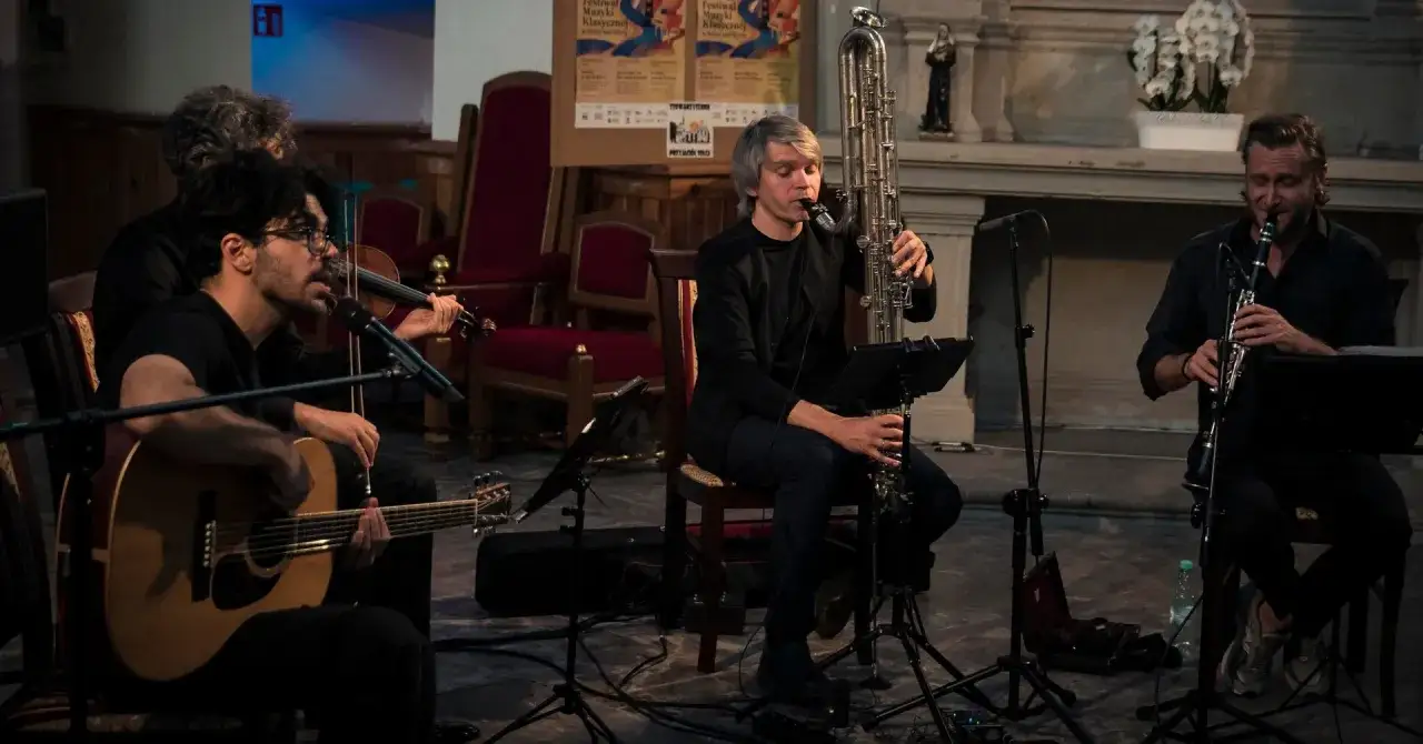 Muzycy grają na gitarze, skrzypcach, klarnecie i saksofonie barytonowym podczas festiwalu muzyki klasycznej w Solcu nad Wisłą.
