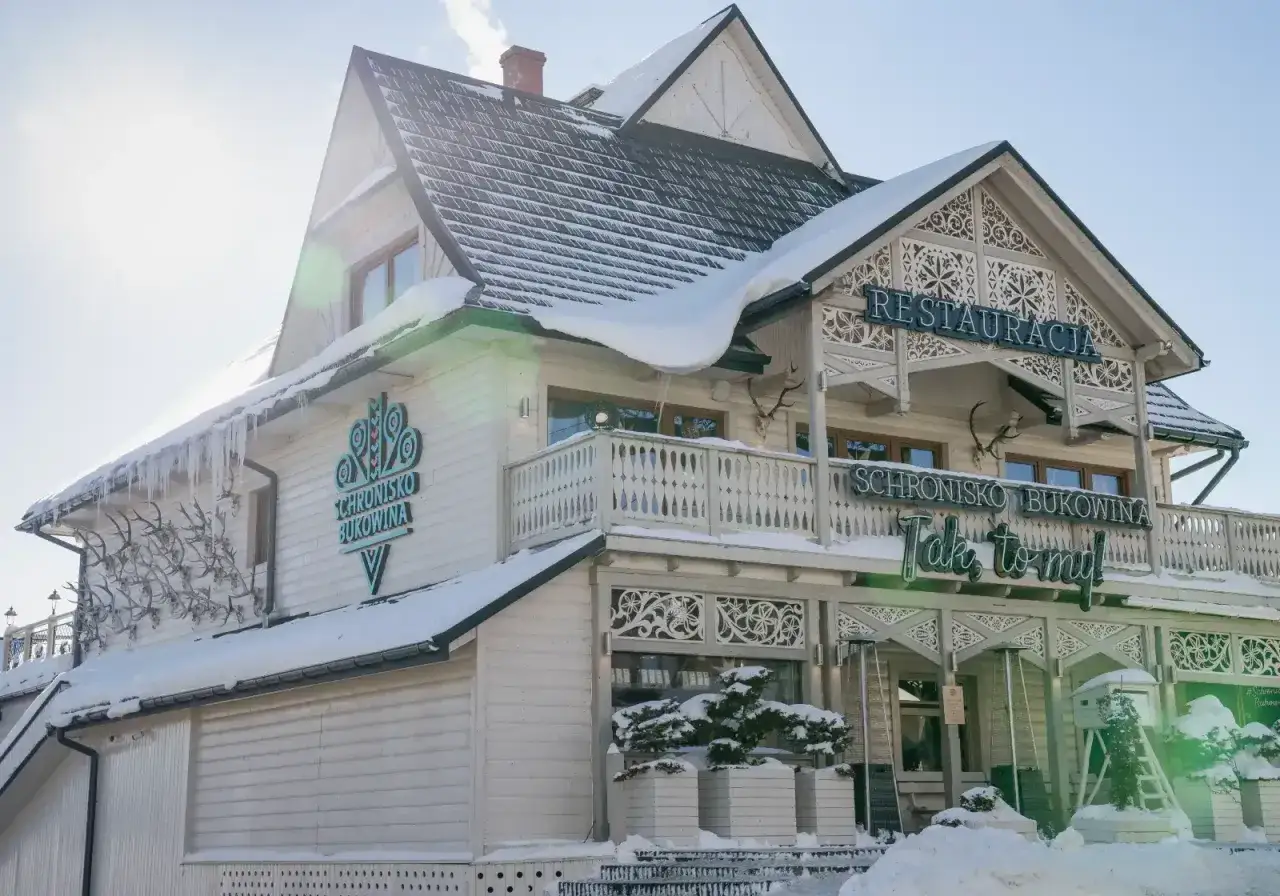 Zimowy widok na Schronisko Bukowina. Na fasadzie widnieje napis 