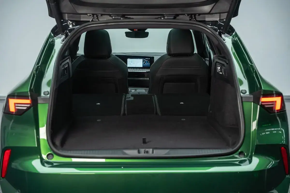 Bagażnik zielonego Opla Astry. Czy to najlepszy Opel? Dużo miejsca na zakupy i podróże.