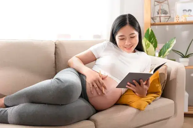 kobieta w ciąży odpoczywająca na kanapie