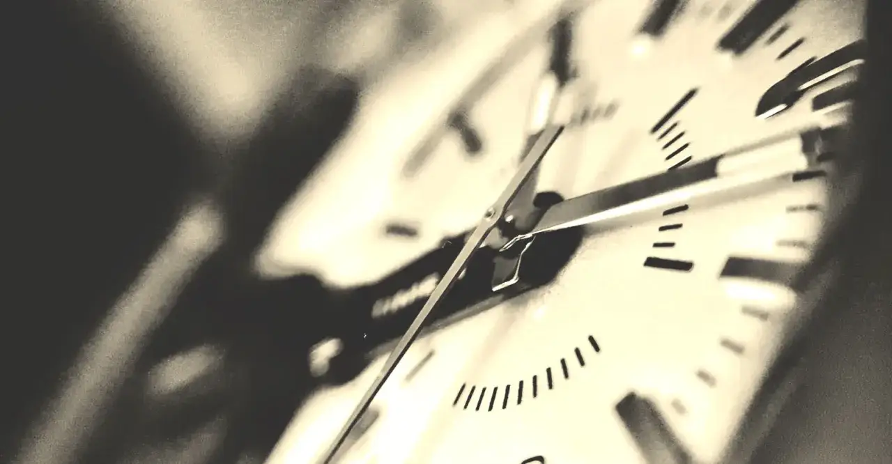 Zbliżenie na tarczę zegara. Czas płynie, a pytanie 