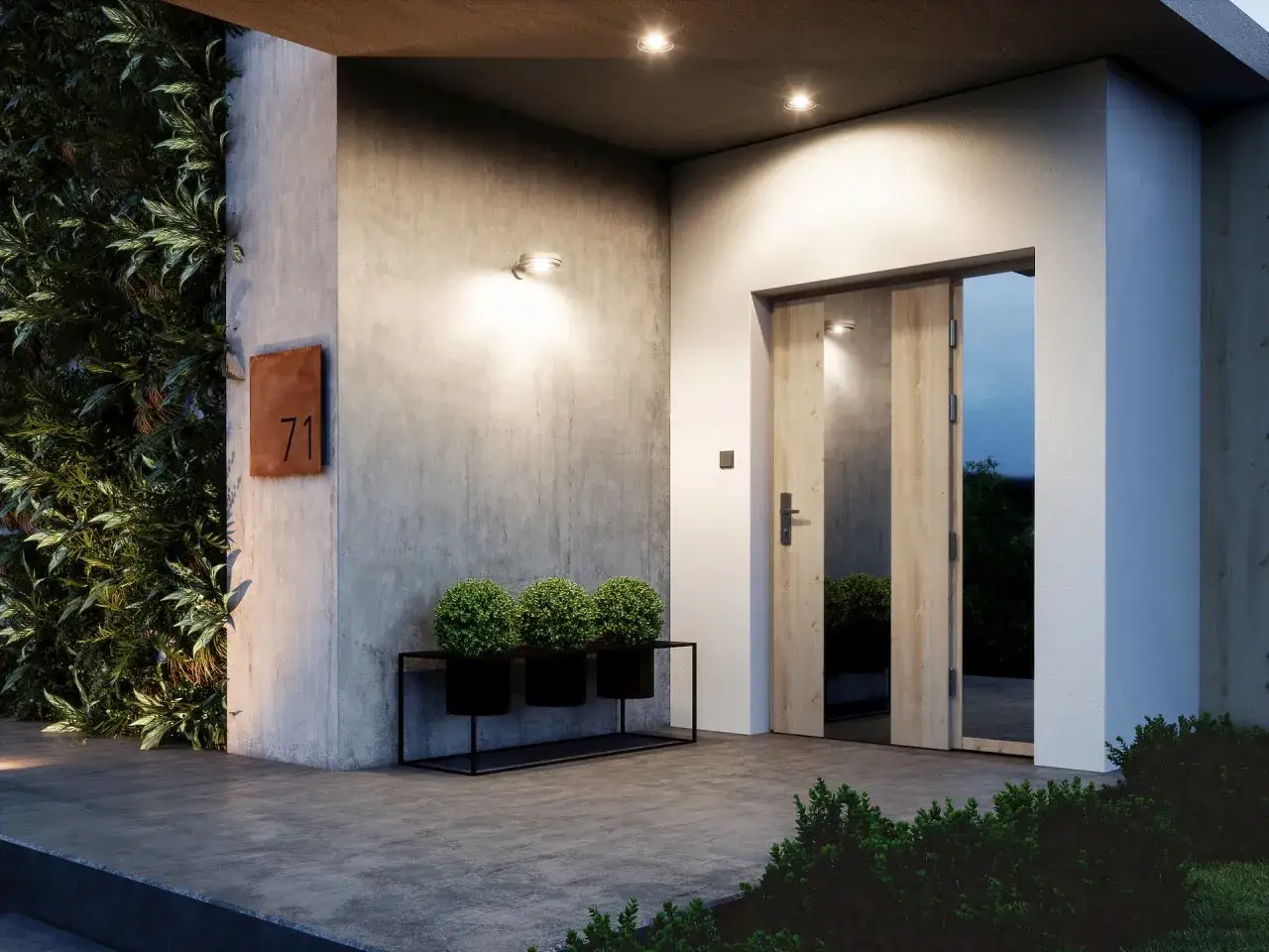 Nowoczesne oświetlenie przed wejściem do domu, z betonową ścianą, zielenią i numerem 71.