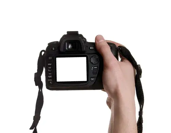 fotograf trzymający w ręku używany aparat fotograficzny