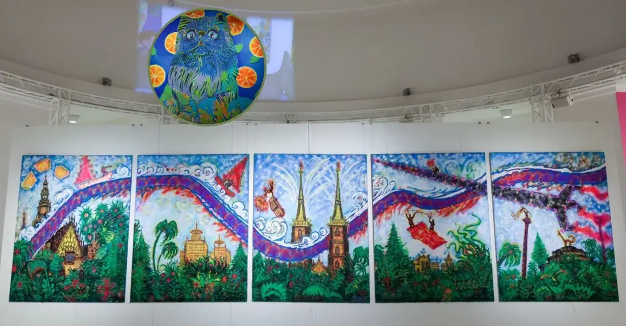 Kolorowe obrazy w muzeum sztuki Wrocław: fantastyczne miasto z wieżami, latającymi ludźmi i niebieskim kotem z pomarańczami.