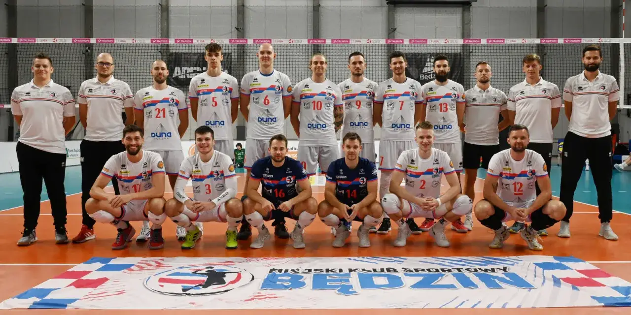 MKS Będzin skład: drużyna siatkarzy w białych i granatowych strojach pozuje do zdjęcia.