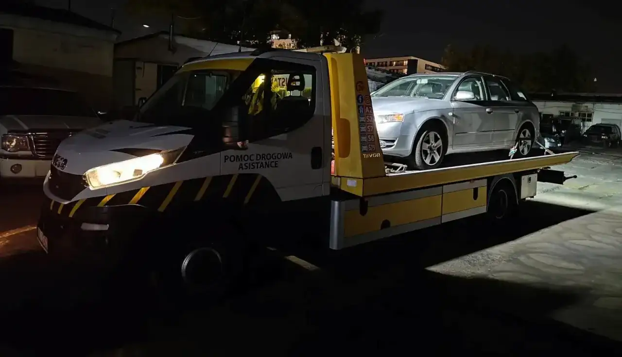 Pomoc drogowa assistance bez OC transportuje srebrne auto.