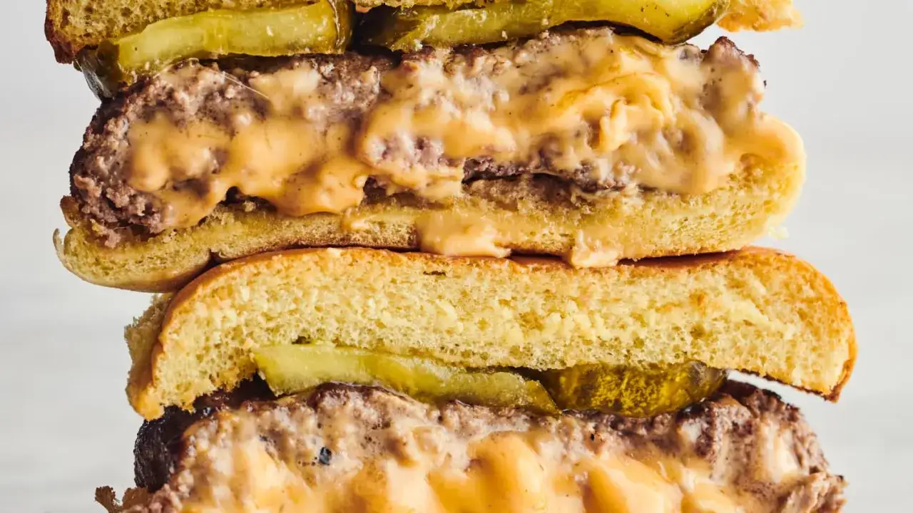 Pyszne, soczyste prawdziwe burgery przepis. Mięso, ser i og&oacute;rek kiszony w puszystej bułce.