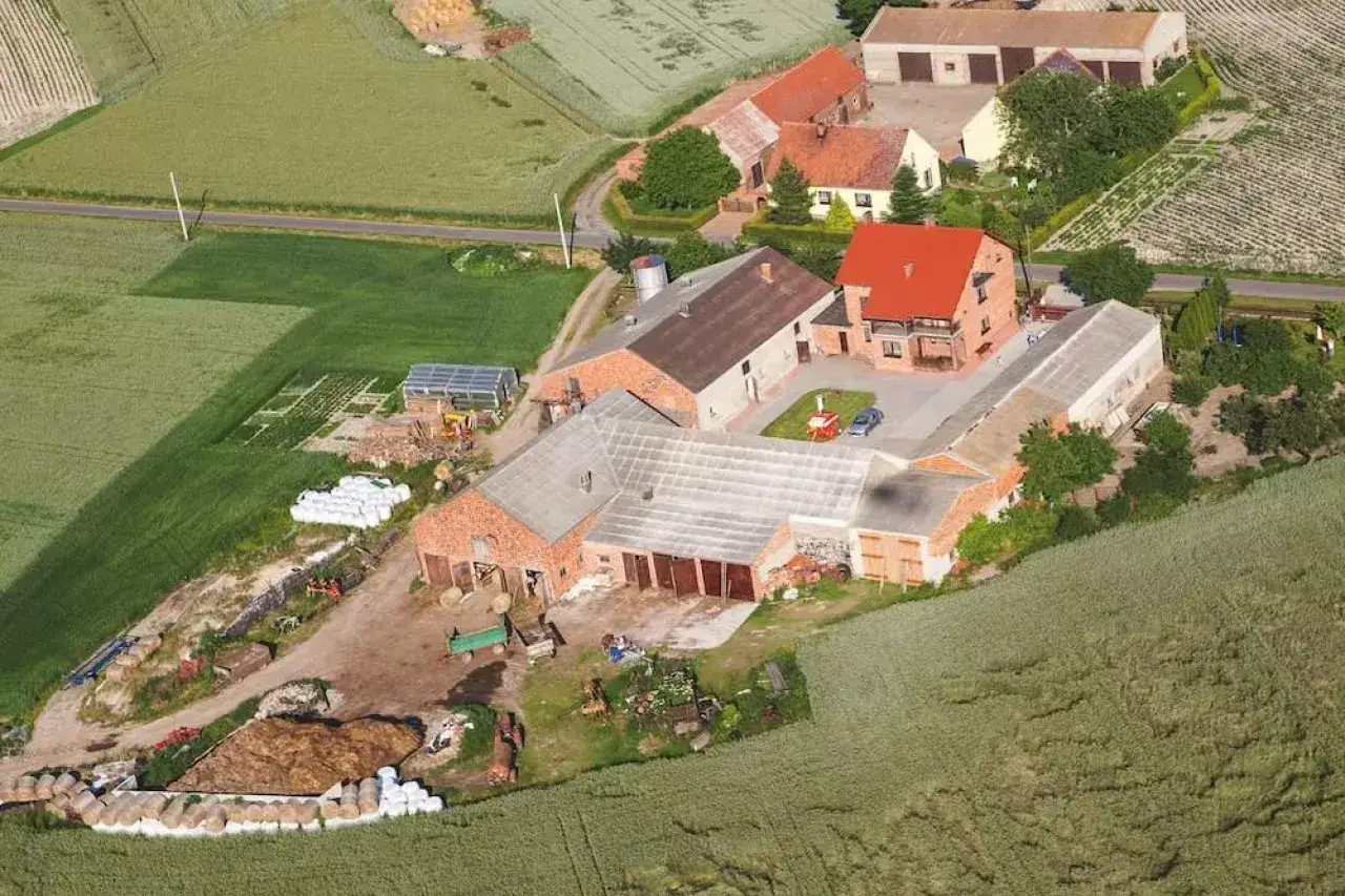 Widok z lotu ptaka na gospodarstwo, gdzie mieszka Jockerfarm. Widać budynki gospodarcze, pola uprawne i stogi siana.