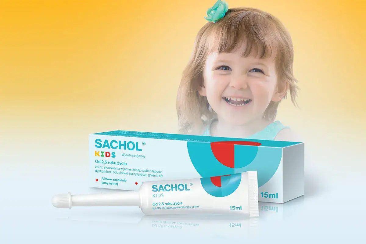 Uśmiechnięte dziecko i opakowanie żelu Sachol Kids na aftowe zapalenie jamy ustnej.