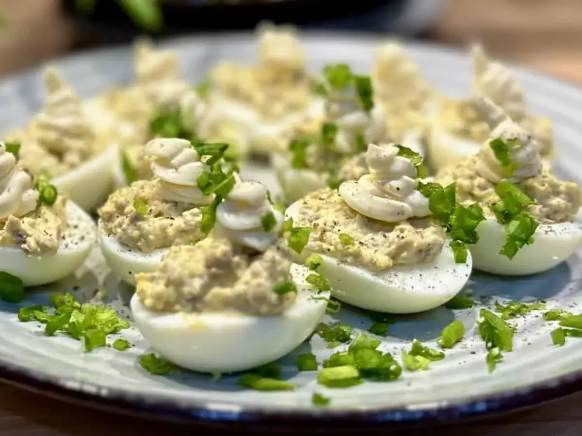 Pyszne jajka faszerowane pieczarkami i szczypiorkiem, udekorowane majonezem. Idealna przekąska na każdą okazję.