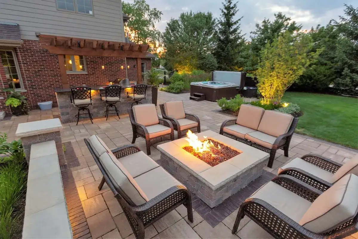 Urokliwe miejsce na palenisko w ogrodzie, z wygodnymi meblami i jacuzzi, idealne na wieczorne spotkania.
