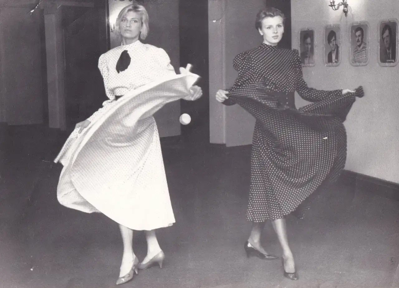 Dwie kobiety w sukienkach w kropki, uosobienie mody damskiej lat 80. Ich stroje wirują, tworząc dynamiczny obraz.