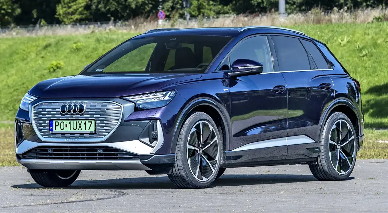 Elegancki, ciemnoniebieski samochód elektryczny Audi Q4 e-tron, idealny dla szukających auta do 30 tys. zł.
