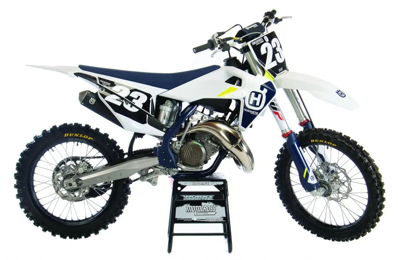 Biały motocykl Husqvarna cross 125 z numerem 23 na tablicy, gotowy do wyścigów.