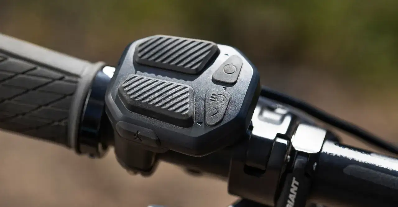 Panel sterowania rowerem elektrycznym z przyciskami do włączania i regulacji świateł. Dowiedz się, jak uruchomić rower elektryczny.