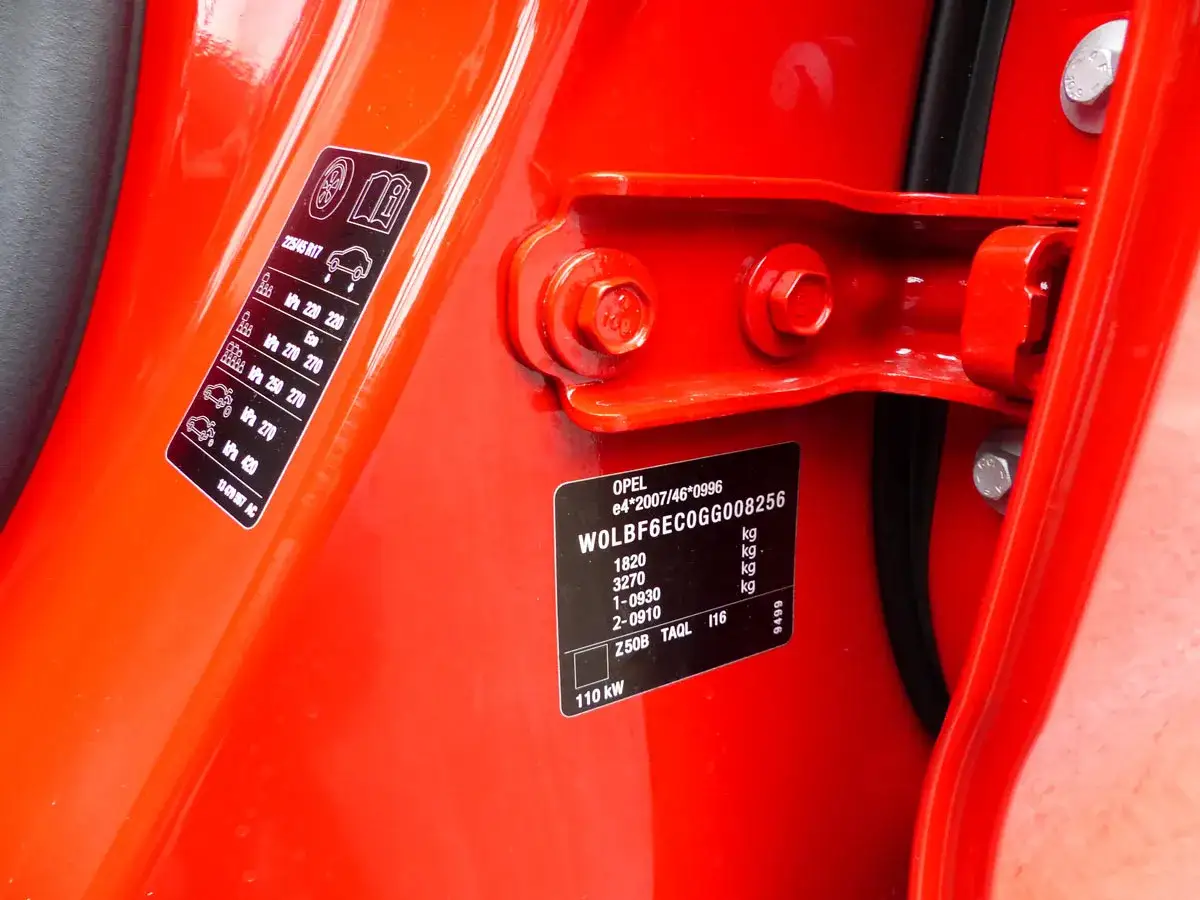 Naklejka z danymi pojazdu Opel, zawierająca informacje o wyposażeniu po numerze VIN, ciśnieniu w oponach i masach.