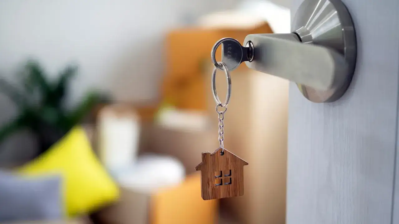 klucze do mieszkania i stos monet, symbolizujące koszty i zyski z wynajmu