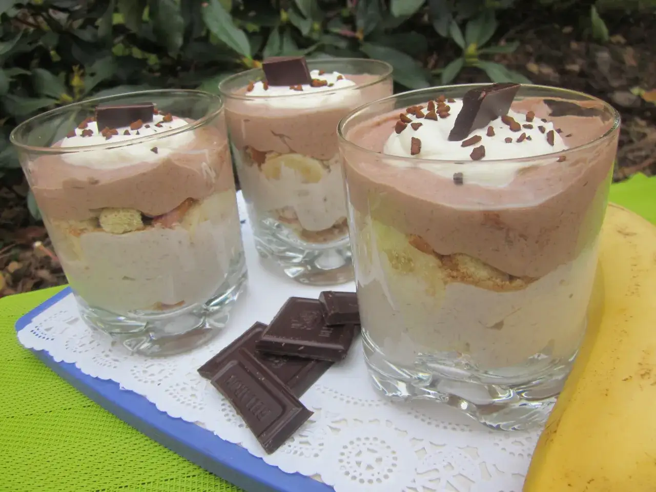 Pyszny deser bananowy przepis w pucharkach. Warstwy musu czekoladowego, śmietany, biszkoptów i bananów.